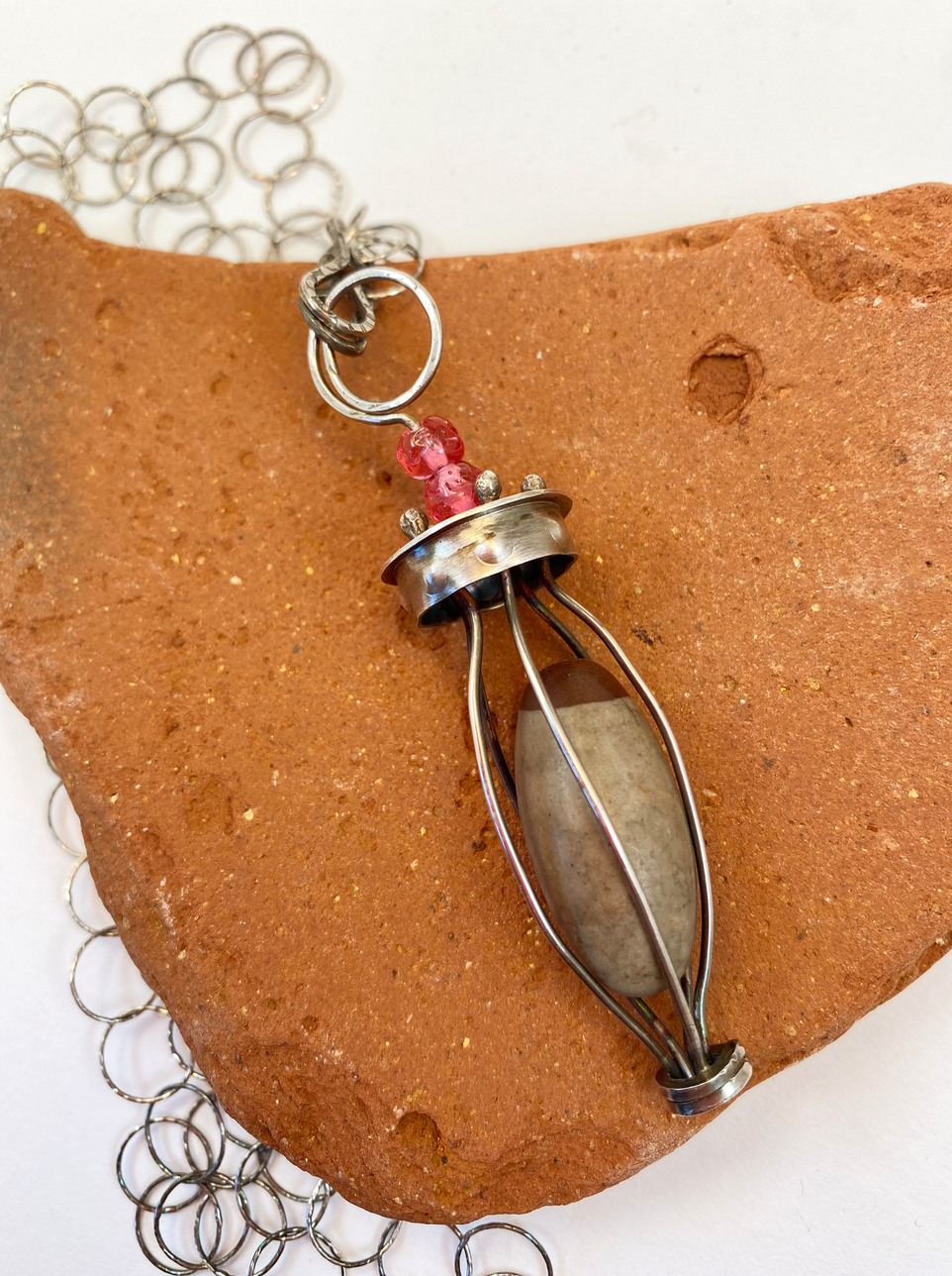 Lingam stone in sterling silver cage with adjustable length sterling silver chain - up to 24" - that can attach in front or in back, with unique handcrafted clasps .