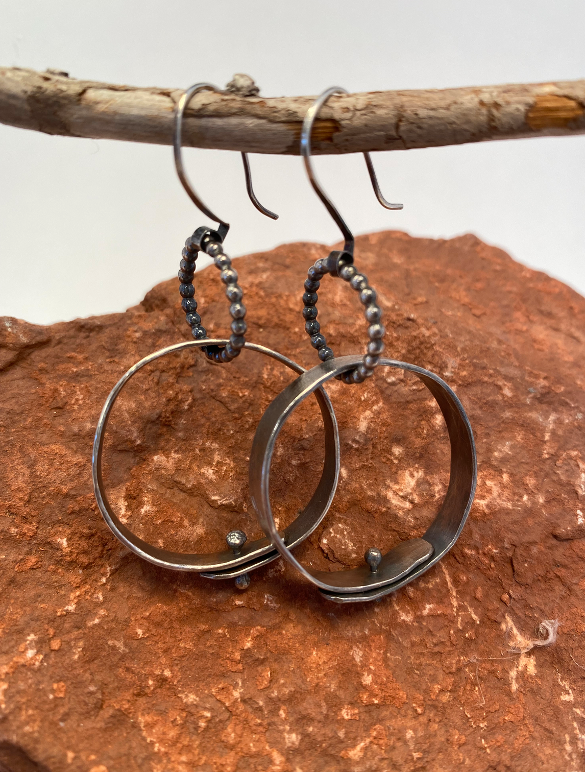 One-of-a-kind hand-crafted sterling silver hoop earrings.  Bead wire rings hold large hand-forged (hammered) hoops with ball-head pins closing them.  Length under ear wire: 1-3/4"  Style: rustic, boho, funky, earthy yet elegant
