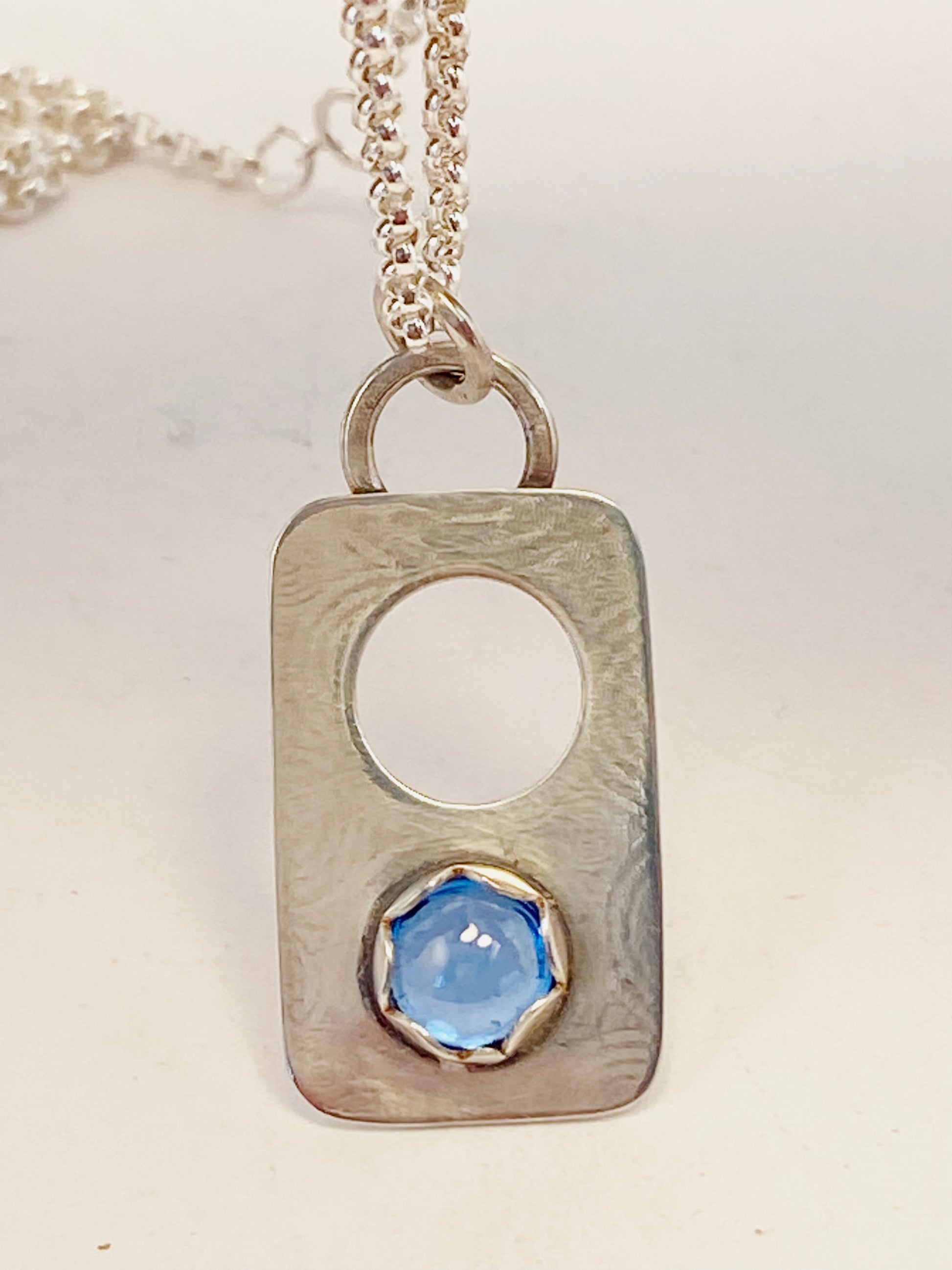Hand-crafted, one-of-a-kind necklace sterling silver pendant featuring London Blue Topaz set in a scalloped bezel on a lightly textured surface, with accent hole.