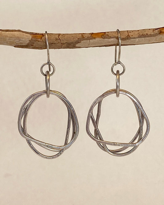 Unique design, hand-crafted sterling silver earrings. Organic shape with clean design. Lightweight. Earrings dance - feel great on!  A flattering shape for almost any face. Handmade ear wire. Each hoop is approx. 1" long; length of drop from ear wire is approx. 1.5". Style: organic, rustic, boho, elemental, earthy yet elegant MATCHING CHAIN NECKLACE AVAILABLE