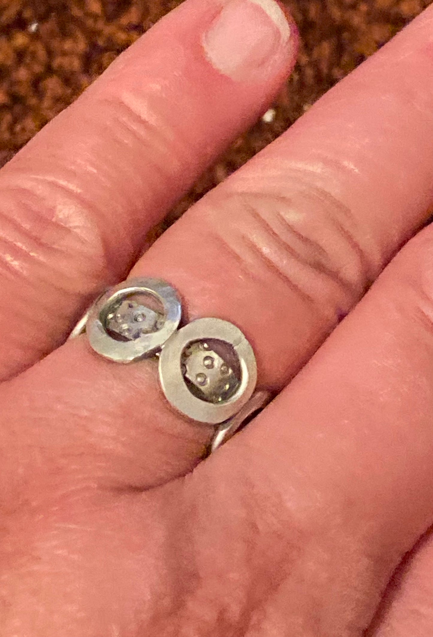 One-of-a-kind sterling silver ring adorned with four smashed hoops around a band textured with tiny stamped circles. Size 7.5.