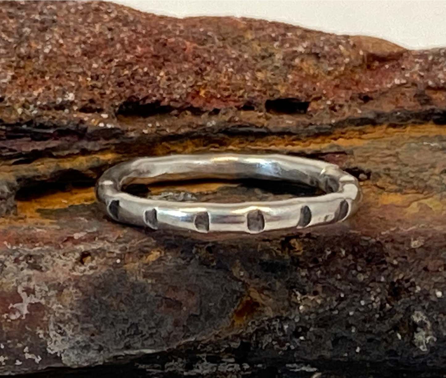 One-of-a-kind hand-crafted ring. Round sterling silver band. Band is adorned with lined stamp pattern. Women's size 4-1/2