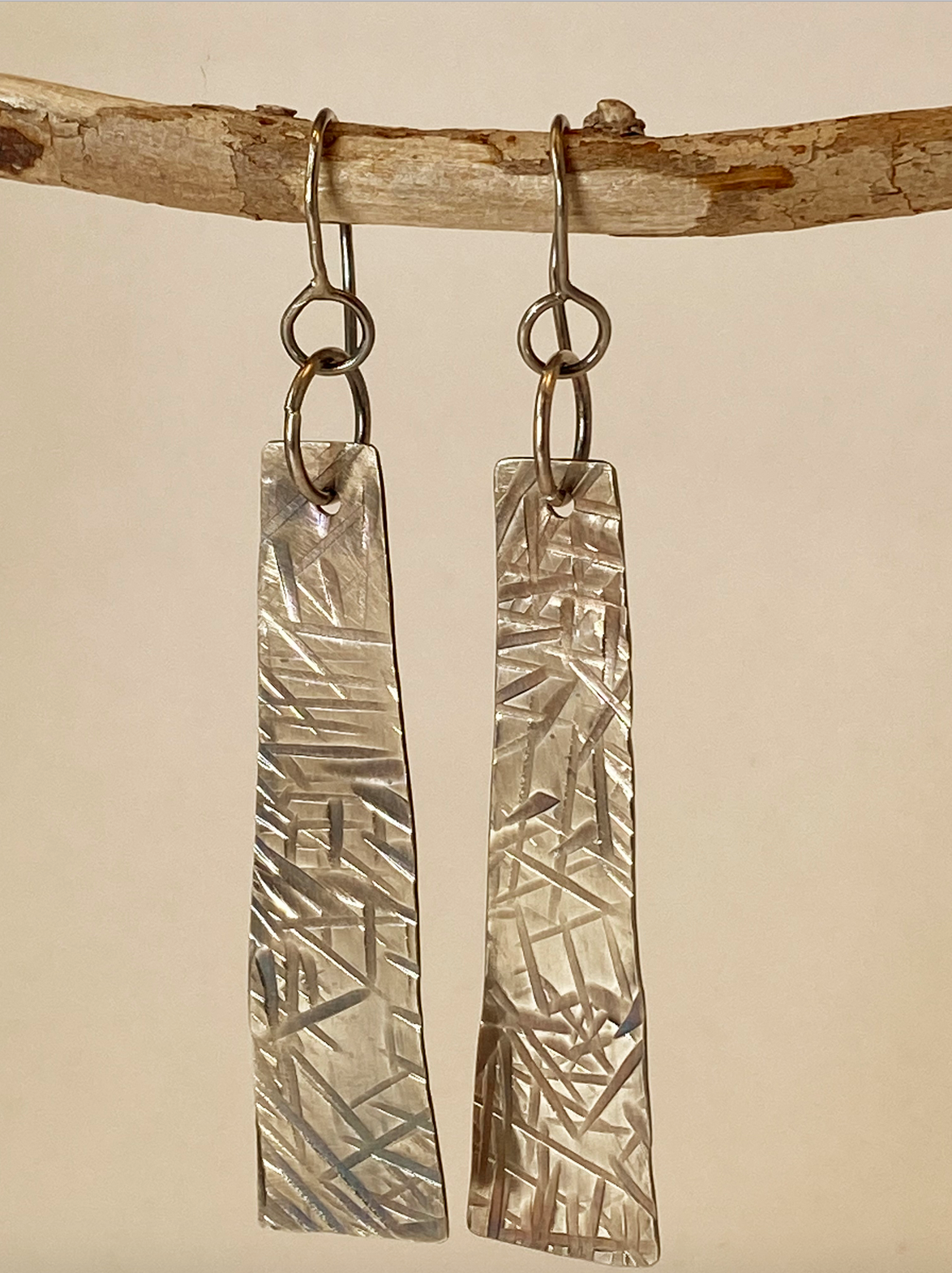One-of-a-kind hand-crafted earrings. Evocative long sterling silver tablet-shaped earrings. Hand-stamped embellishments. A flattering shape for almost any face. Stellae are 2" long x 1/2" wide. Handmade ear hook and ring add length. Style: rustic, boho, elemental, earthy yet elegant