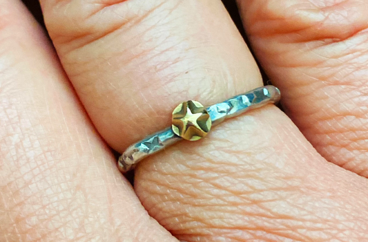 One-of-a-kind hand-crafted stacker ring.  Unique Sterling Silver band is adorned with random star stamp patterns 14k gold star embellishment Beautiful alone or with other rings Ring size 7-1/4 Style: rustic, boho, funky, organic, earthy yet elegant