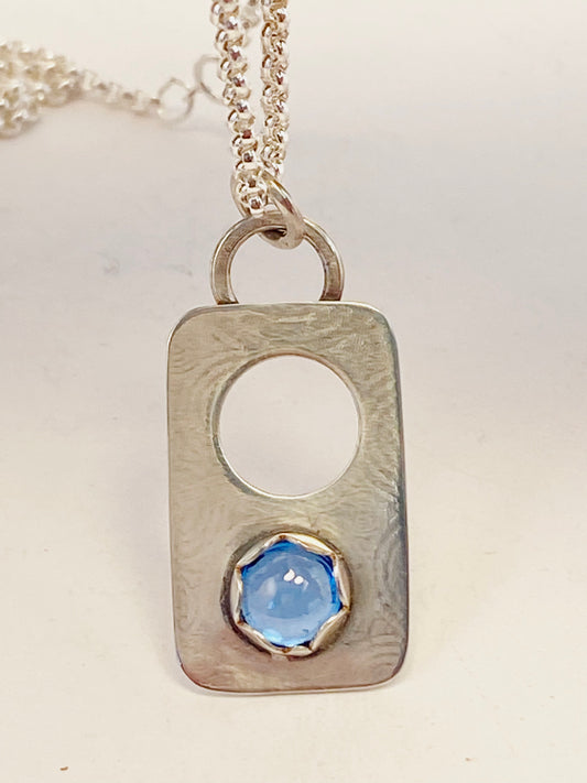 Hand-crafted, one-of-a-kind necklace sterling silver pendant featuring London Blue Topaz set in a scalloped bezel on a lightly textured surface, with accent hole.