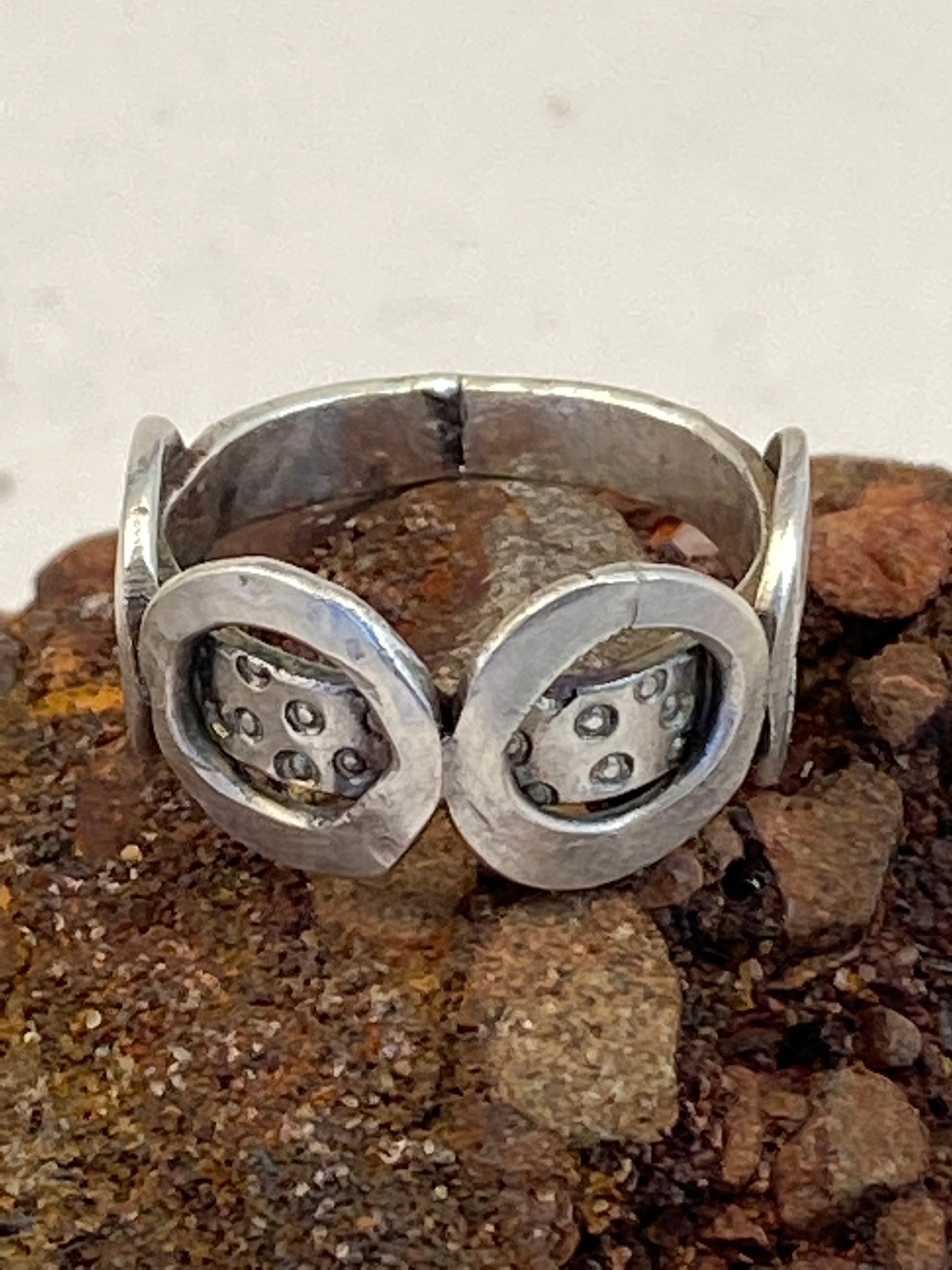 One-of-a-kind sterling silver ring adorned with four smashed hoops around a band textured with tiny stamped circles. Size 7.5.