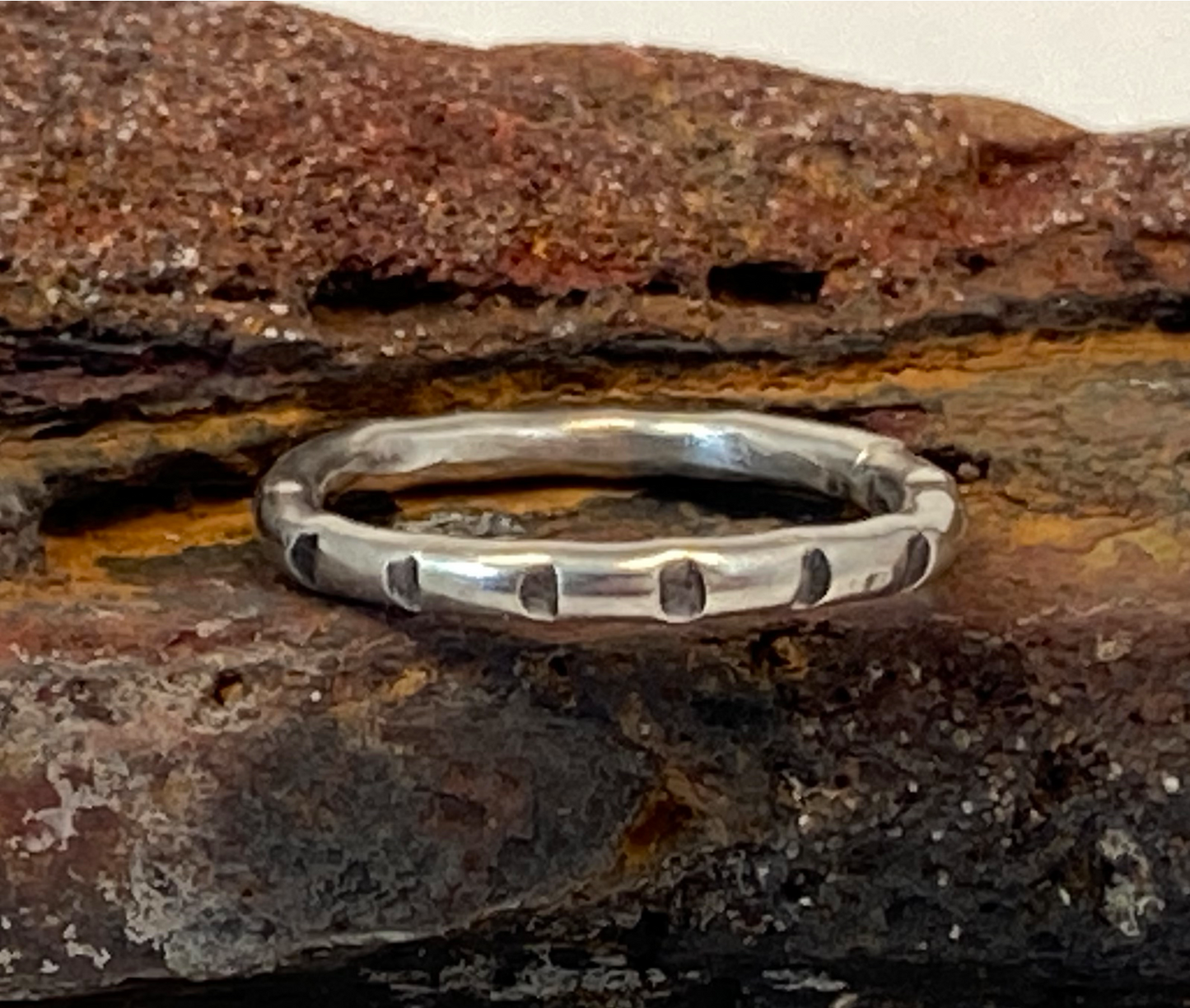 One-of-a-kind hand-crafted ring.  Round sterling silver band. Band is adorned with lined stamp pattern. Women's size 4-1/2