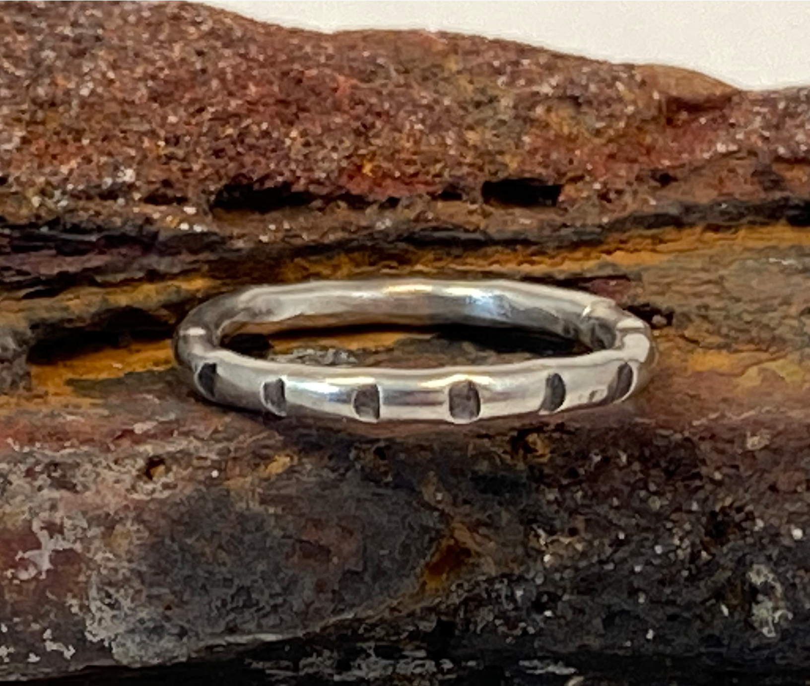 One-of-a-kind hand-crafted ring.  Round sterling silver band. Band is adorned with lined stamp pattern. Women's size 4-1/2