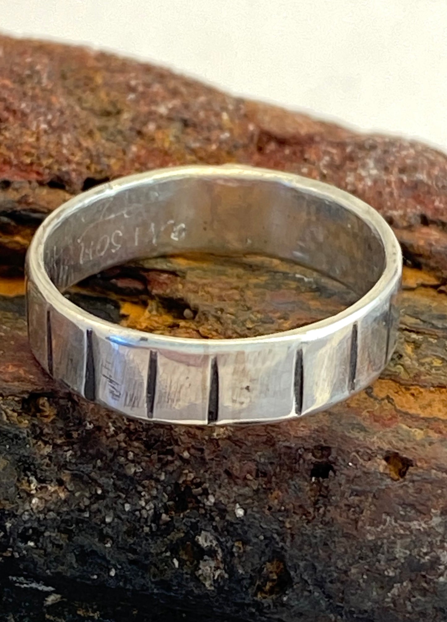      This one-of-a-kind sterling silver ring is adorned with a 14k gold disk and a stamped line pattern around the band.      Ring size 6-14.  Band is 3/16" wide.     Style: rustic, boho, funky, organic, earthy yet elegant