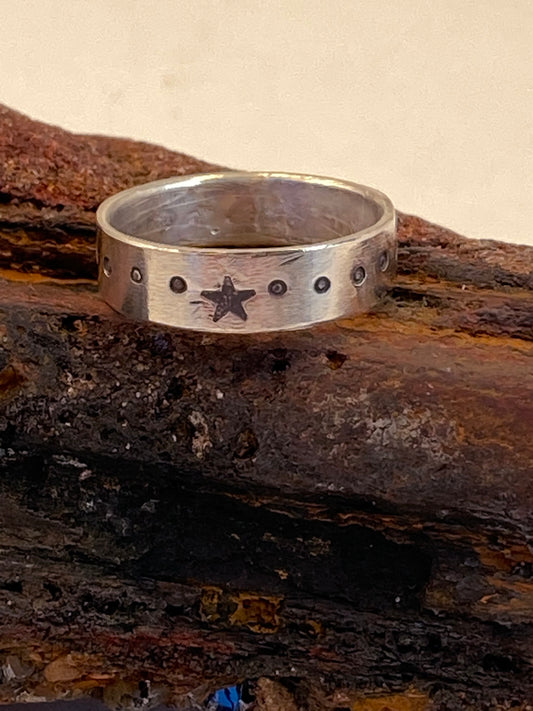 One-of-a-kind hand-crafted sterling silver "cigar band" ring. Band is adorned with an accent star, and with dots stamped around the ring. Ring size 8-1/4. Style: rustic, boho, funky, organic, earthy yet elegant.