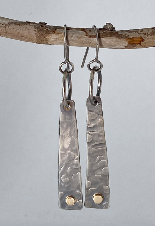 Evocative long sterling silver tablet-shaped earrings. 14k gold embellishments. Hand-stamped texture. A flattering shape for almost any face. Stellae are 1-1/5" long x 3/8" wide at base. Handmade ear hook and ring add length.  Style: rustic, boho, elemental, earthy yet elegant