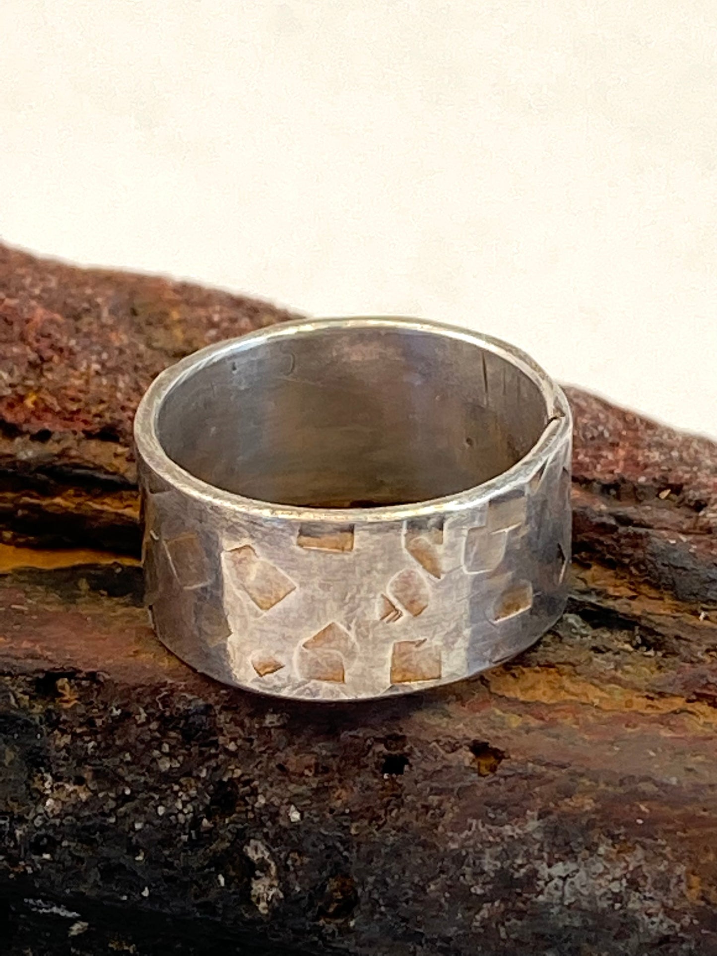 One-of-a-kind hand-crafted sterling silver "cigar band" ring.      Band is beautifully textured with squarish organic shapes.     Gorgeous organic patina that will evolve with you as you wear it.      Ring size 5-1/4.      Style: rustic, boho, funky, organic, earthy yet elegant.